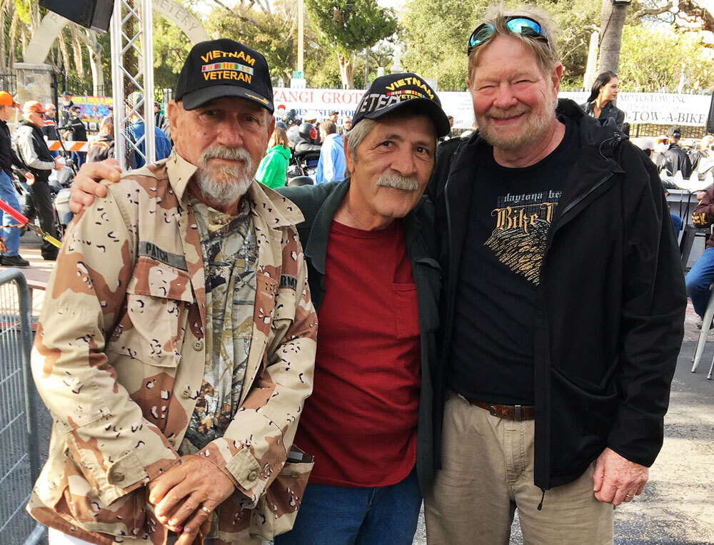 A group of Vietnam Veterans smile at the camera. 