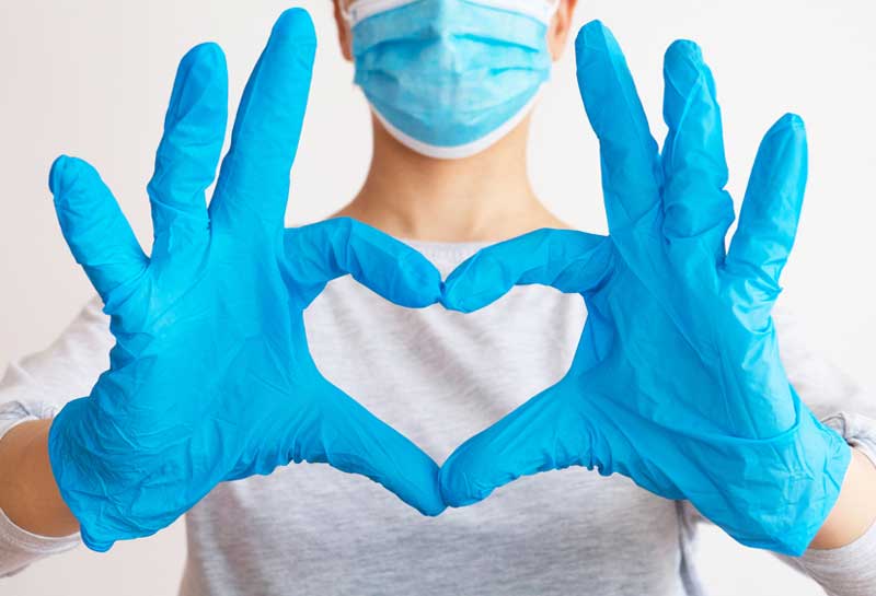 doctor, wearing gloves, making heart with fingers
