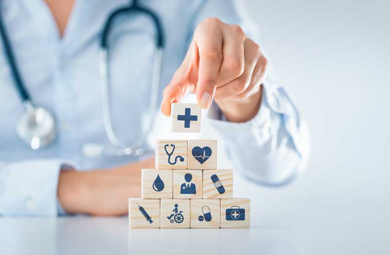 a doctor places blocks with medical symbols in pyramid shape