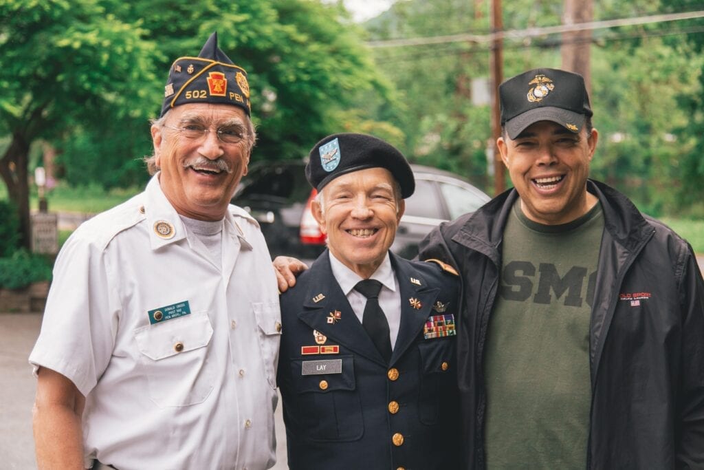 Far from being Veterans in crisis, a group of three Veterans smile at the camera.