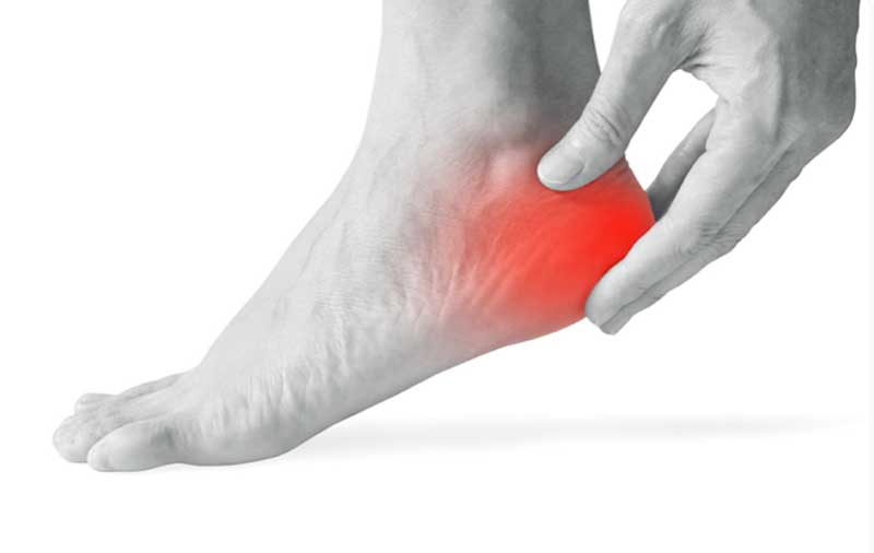 A Veteran massages their heel with plantar fasciitis pain.